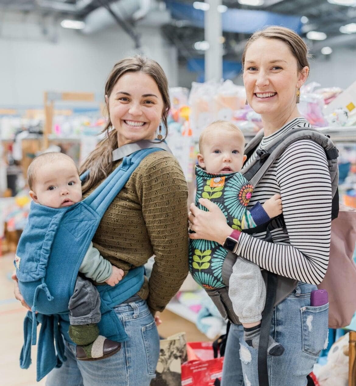 Two moms with babies in carriers shopping together