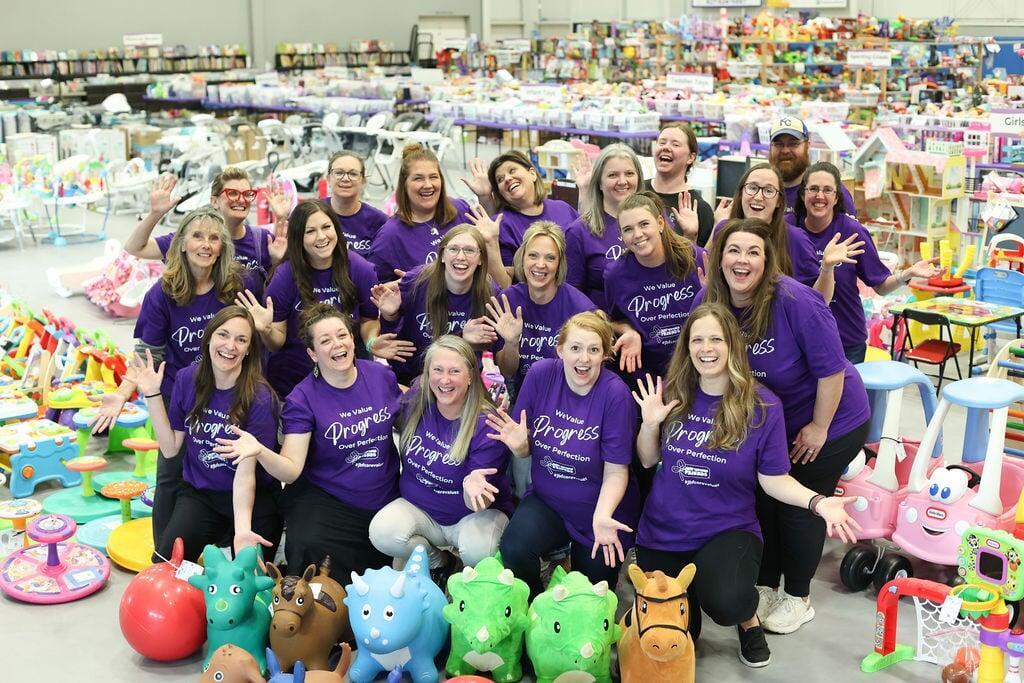 JBF Springfield team standing in front of rows of clothing